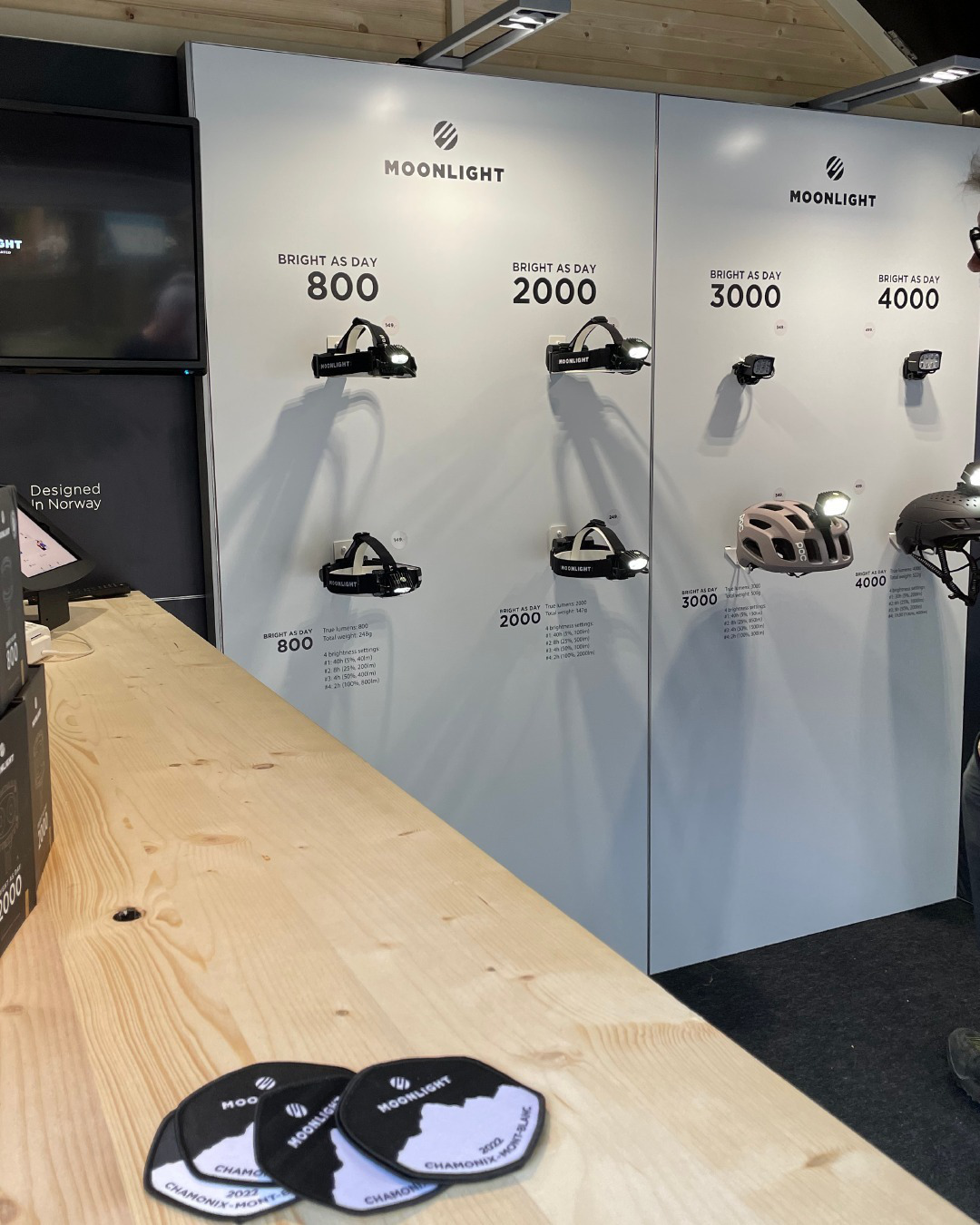 A stand showcasing head lights gear and patches on a board.